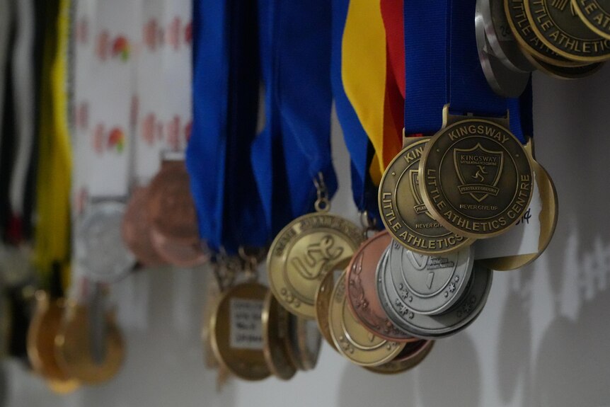 A bunch of medals hanging in a room.