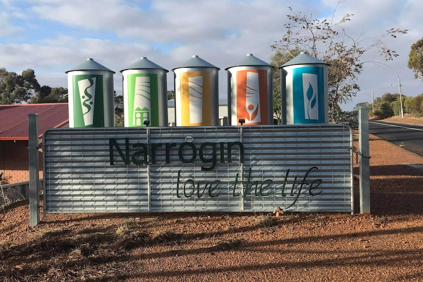 A town sign under a bright blue sky.