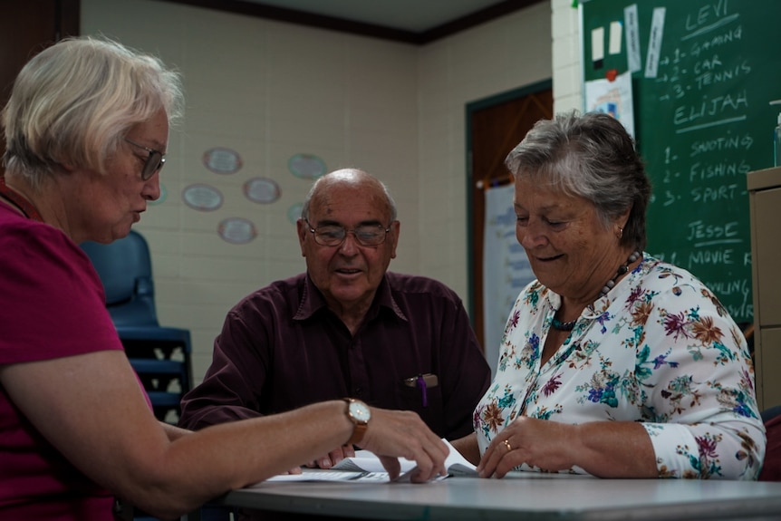 man and two women around table 