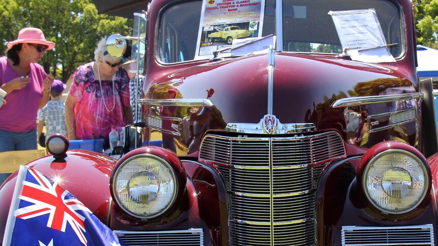 Two women admire a car at the Carnival Classic Cars.