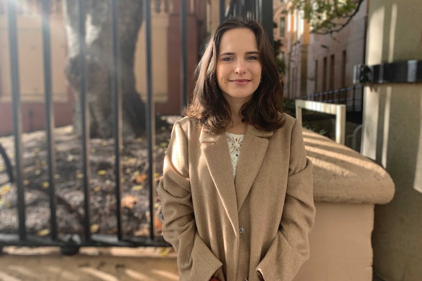 a woman standing in front of a fence