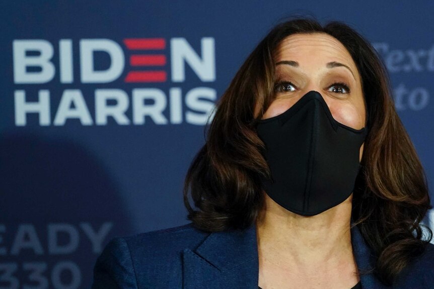 Democratic vice presidential candidate Kamala Harris talks while wearing a face mask.