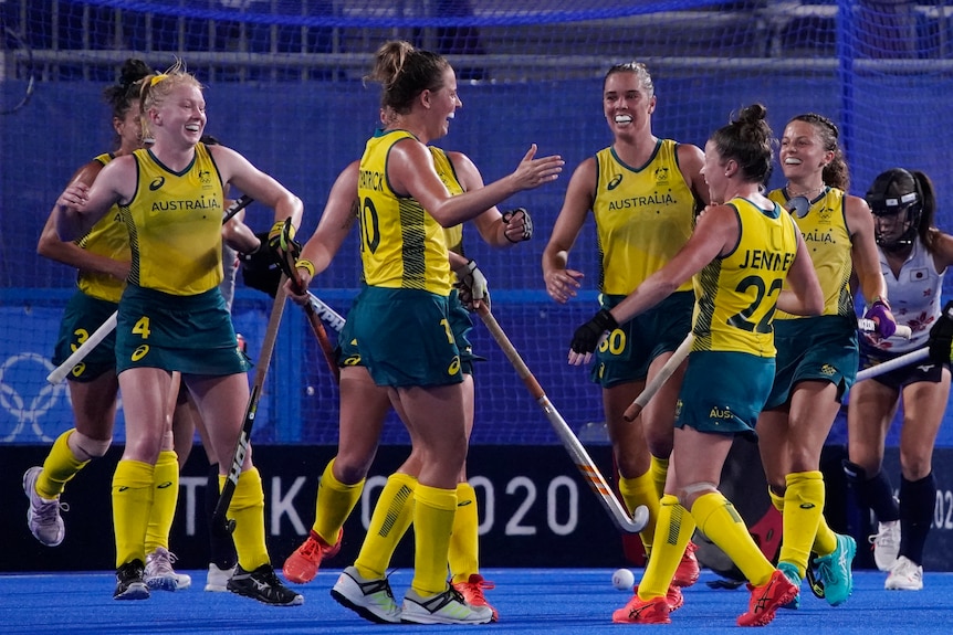A group of Australian female hockey players celebrate a goal against Japan at the Tokyo Olympics.