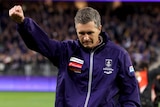 Fremantle Dockers coach Justin Longmuir celebrates a win with his right fist in the air.
