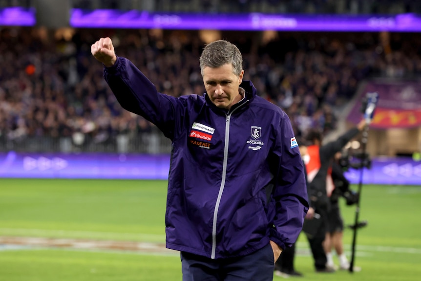 Fremantle Dockers coach Justin Longmuir celebrates a win with his right fist in the air.