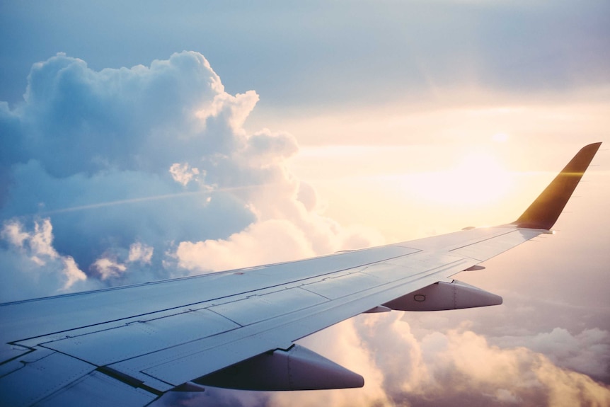 The view of a plane's wing from the inside of the cabin, representing debt accrued from travelling in your twenties.