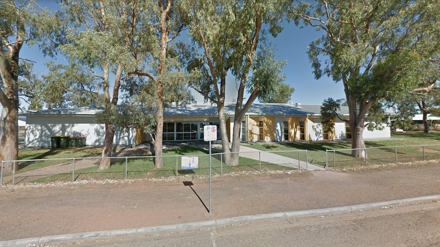 A Google Street View screenshot of a school, with eucalypt trees and a road in the foreground.