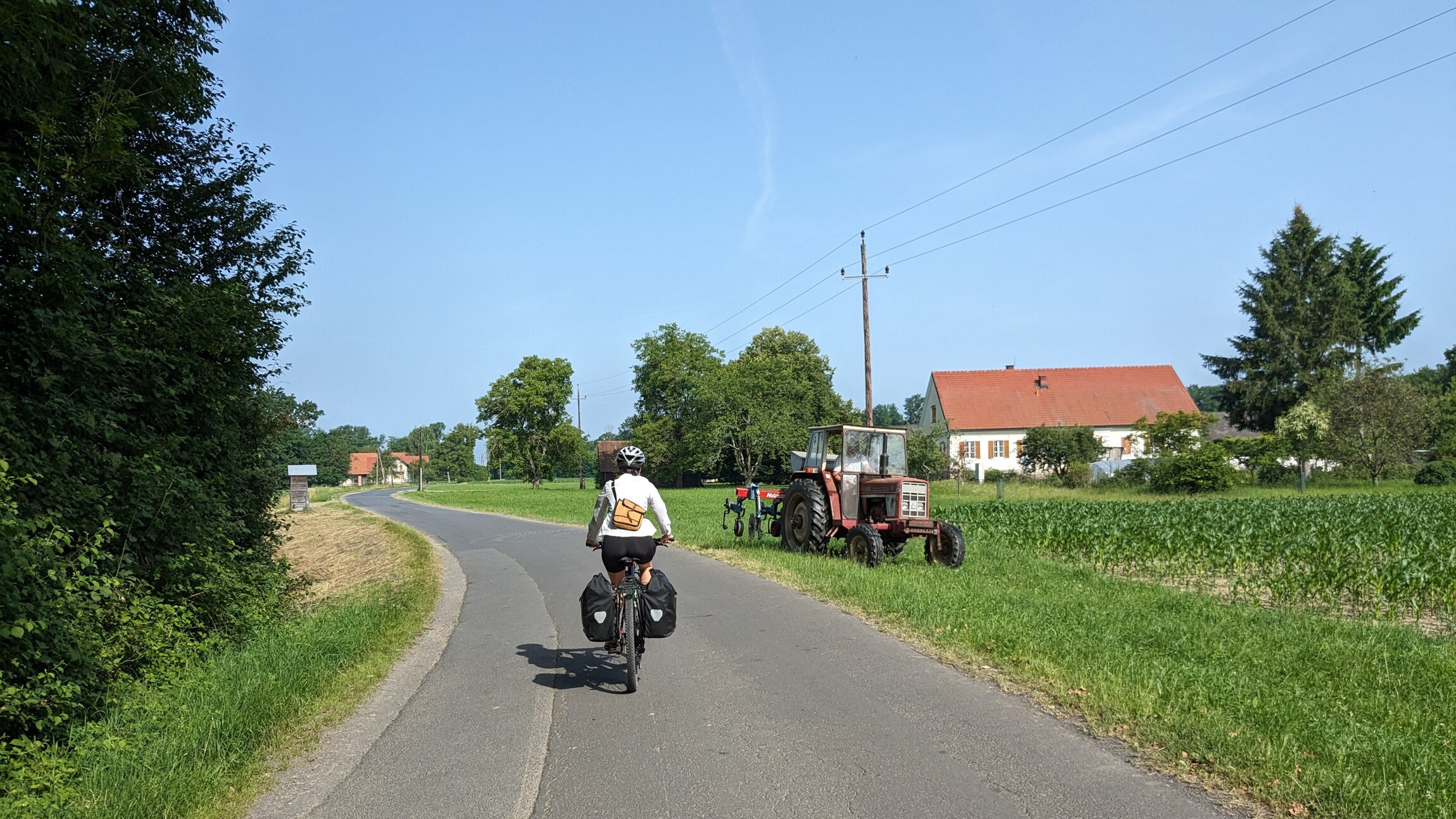 A bicycle rider rides their bike down a bicyle path in the European countryside.