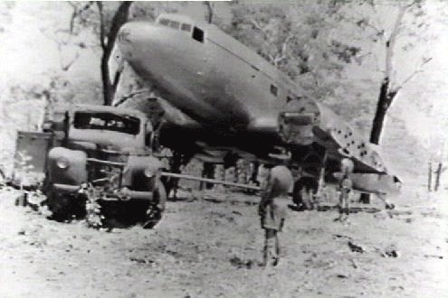 Black and white image of a plane which crashed, being towed