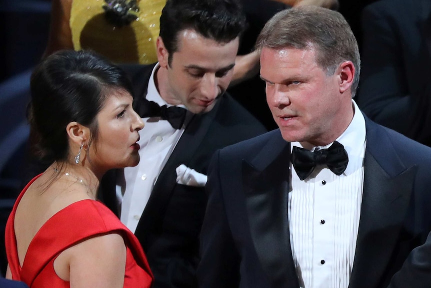 Brian Cullinan and Martha Ruiz confer on stage after the Best Picture was mistakenly awarded to La La Land instead of Moonlight