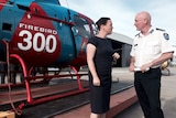 Jane Garrett, Craig Lapsley talk next to the Firebird 300 helicopter.