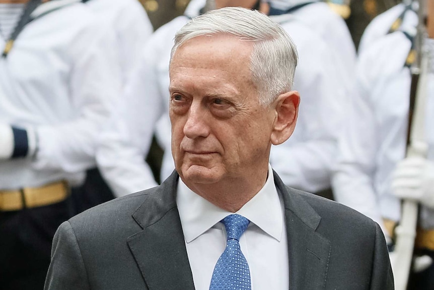 US Secretary of Defence James Mattis walks past honour guards standing to attention.