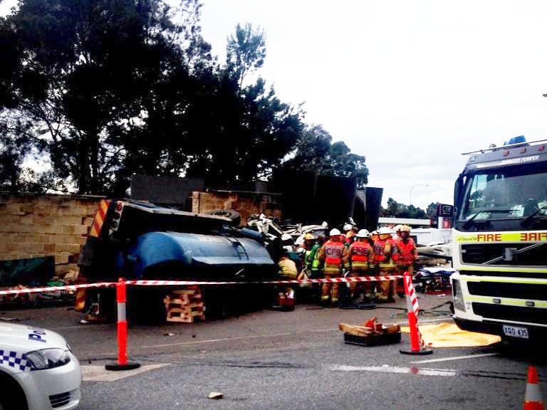 Emergency workers crowd around vehicle wreckage.