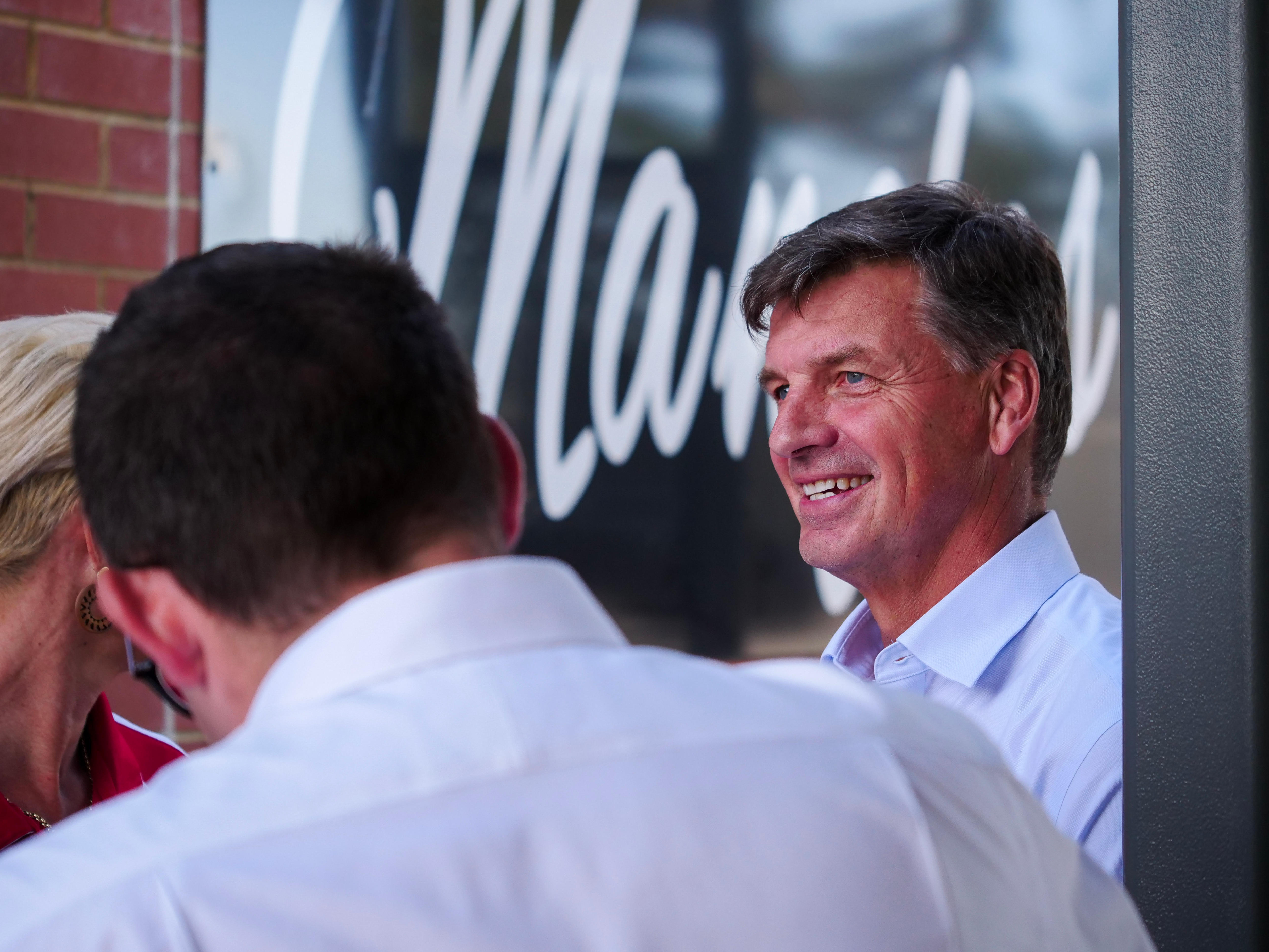um homem vestindo uma camisa de colarinho azul sorrindo