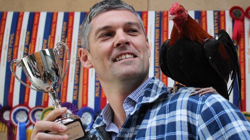 Albany poultry breeder Nathan Watson poses for a photo with his prize winning bantam on his shoulder.