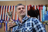 Albany poultry breeder Nathan Watson poses for a photo with his prize winning bantam on his shoulder.