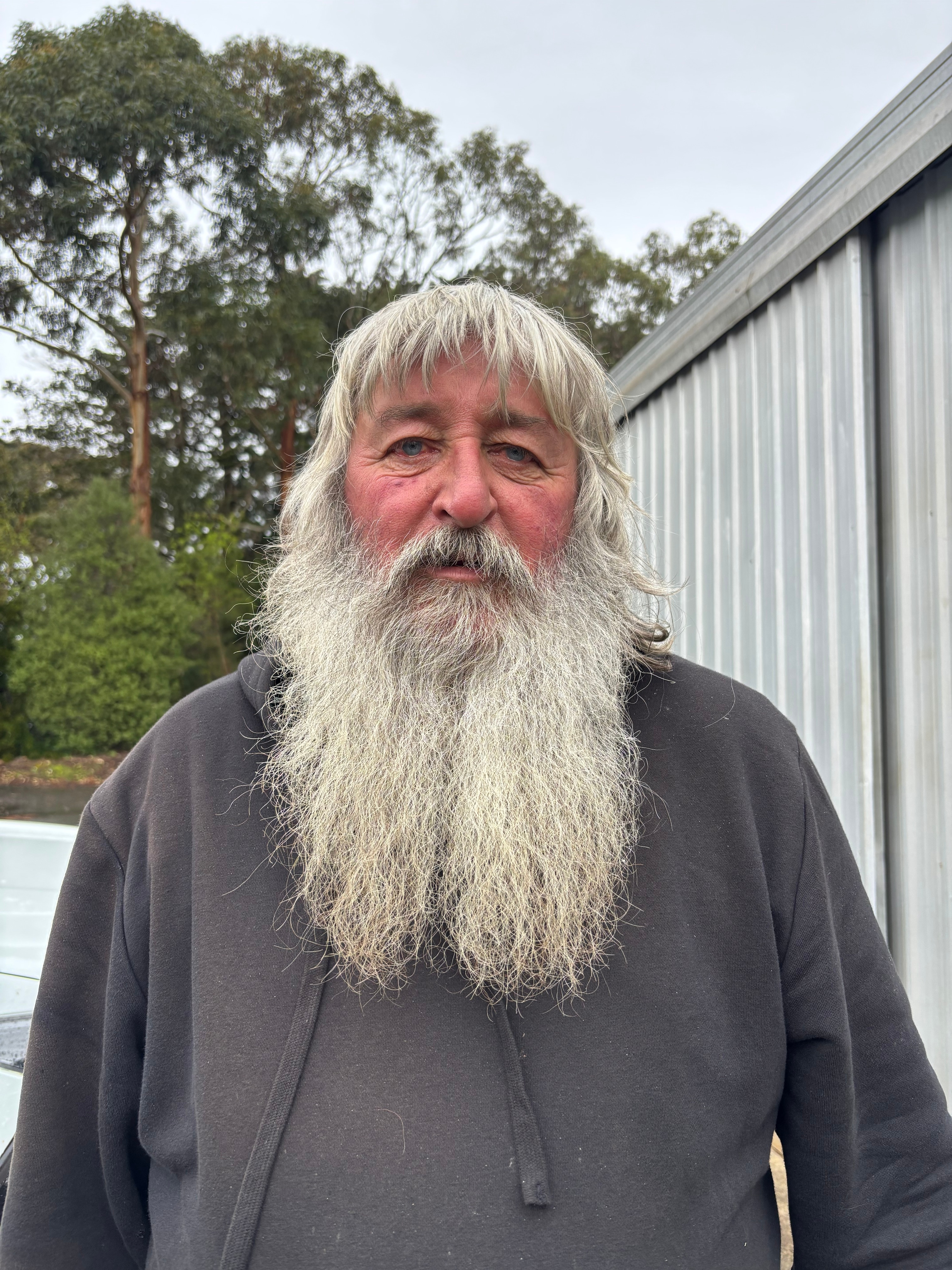 A portrait photo of a man with a long grey beard.