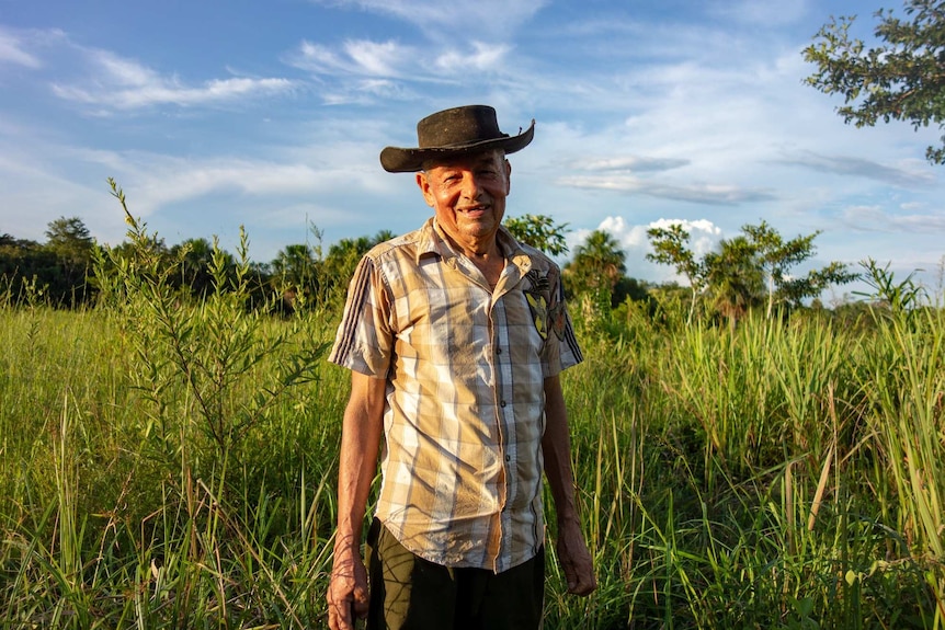 A man in a hat smiles at the camera