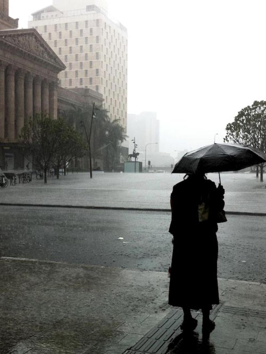A Brisbane resident watches the rain at the end of the Queen Street Mall on January 11, 2011.