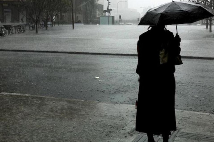 A Brisbane resident watches the rain at the end of the Queen Street Mall on January 11, 2011.