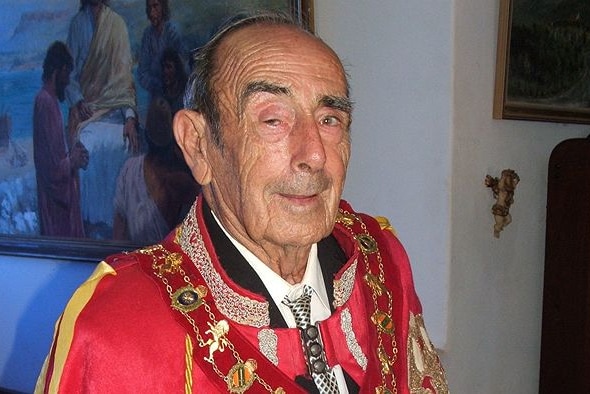 Man in red robes with a gold chain around his neck