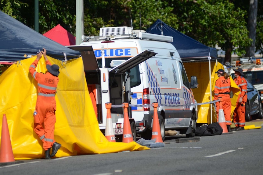SES workers put up barriers to cover the scene of a deadly stabbing.