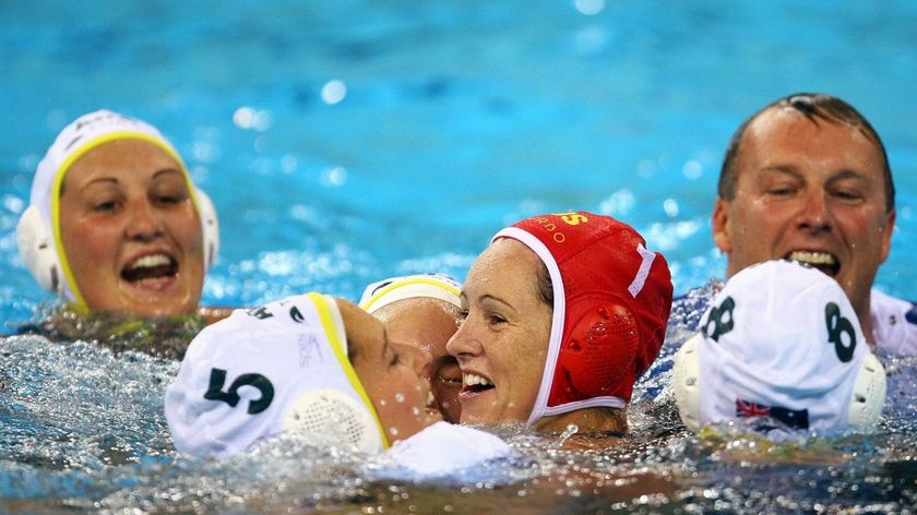 The Australian women's water polo team, including coach Greg McFadden, celebrate bronze