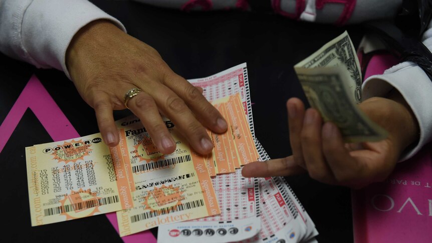 A person picks up California Powerball lottery tickets.