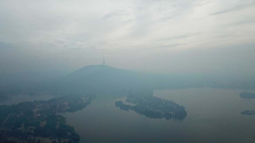 Telstra Tower can just be seen through the haze of smoke, in an aerial photo taken by drone.