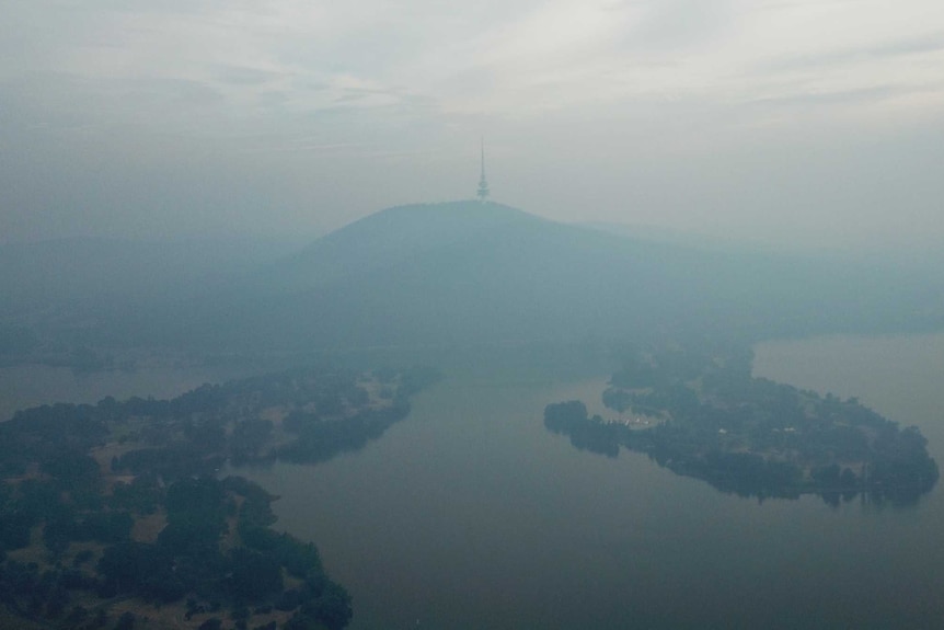 Telstra Tower can just be seen through the haze of smoke, in an aerial photo taken by drone.