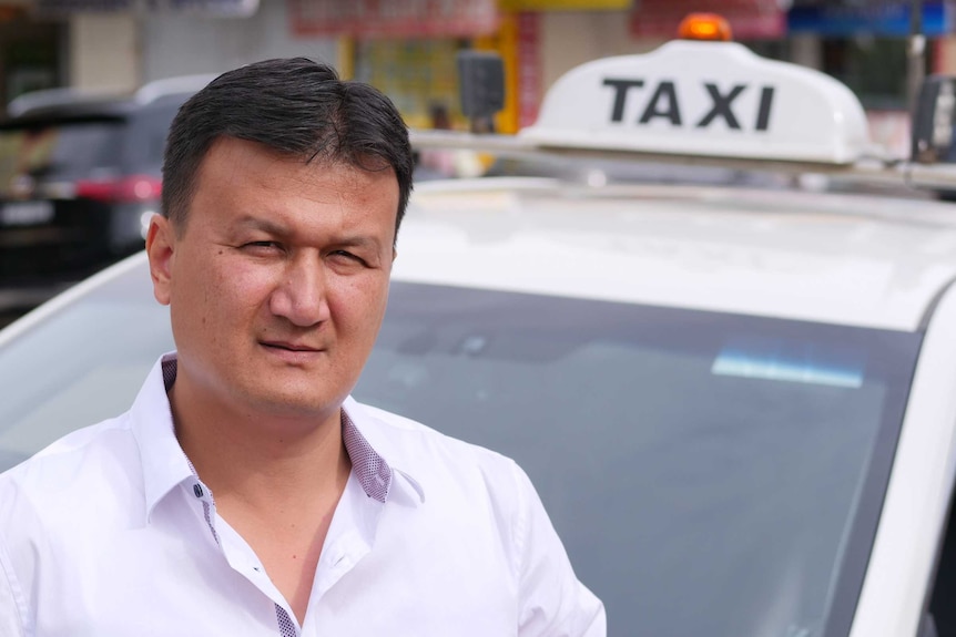 Sydney taxi drive Amir Mohammad stands by his cab March 2020.