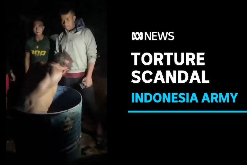 Torture Scandal, Indonesia Army: A naked man in an open barrel while two men watch him.