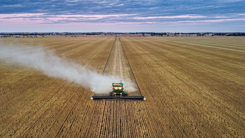 Drone shot of a combine harvester working in a field.