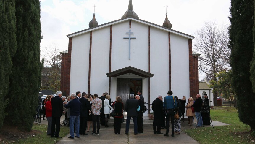 People gather to honour the victims of flight MH17 at the Ukrainian Orthodox Church of Saint Nicholas.