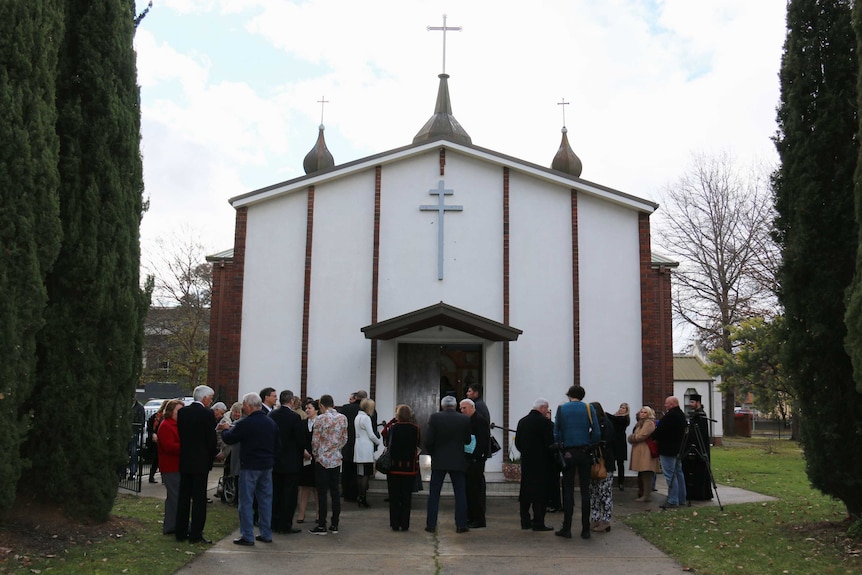 People gather to honour the victims of flight MH17 at the Ukrainian Orthodox Church of Saint Nicholas.