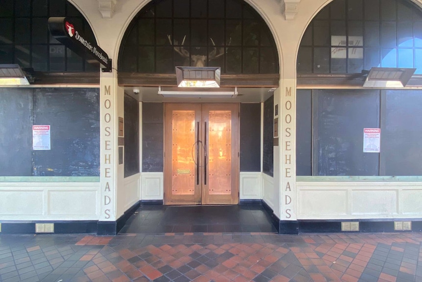 A pub with doors closed and windows boarded.