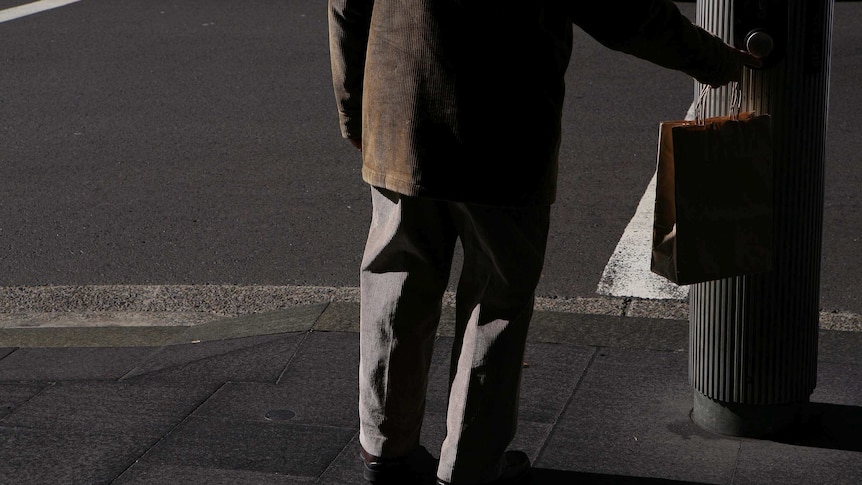 Elderly man crosses the lights