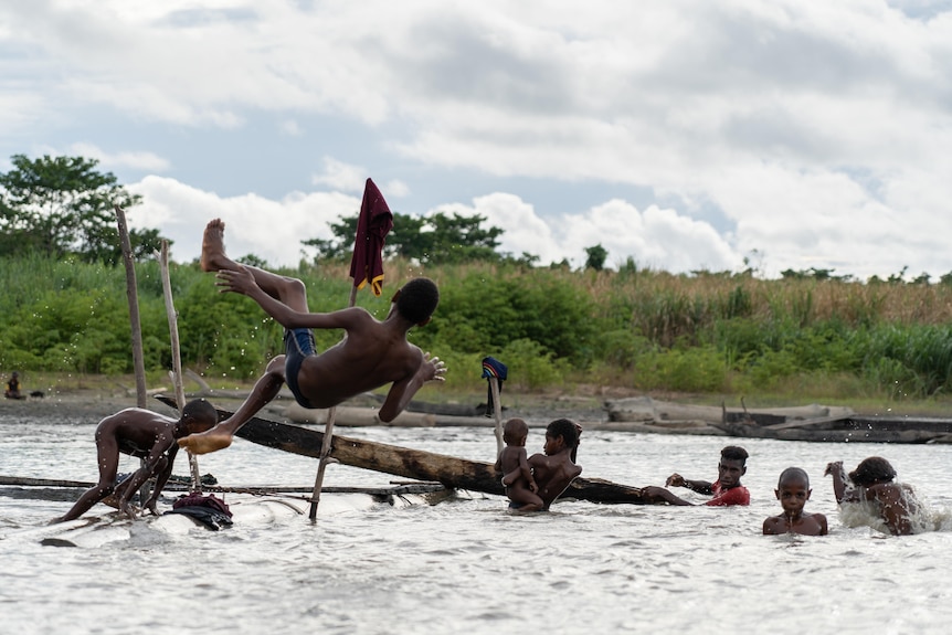 Kids jump in the water.