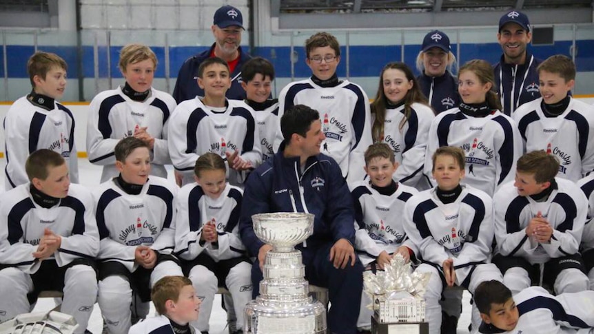 Sidney Crosby (centre) with the NHL Stanley Cup with young players including Queenslander Courtney Mahoney.