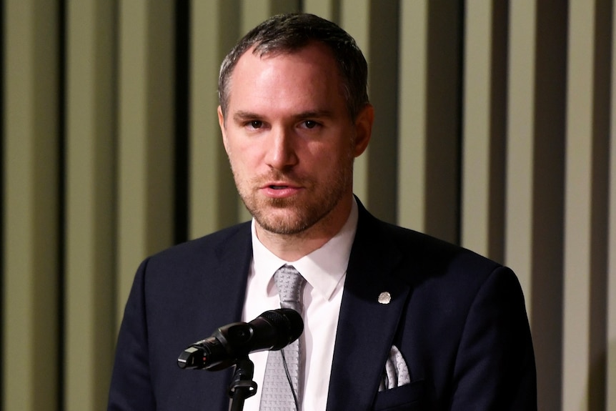 Zdenek Hrib speaks into a microphone. He is wearing a suit.