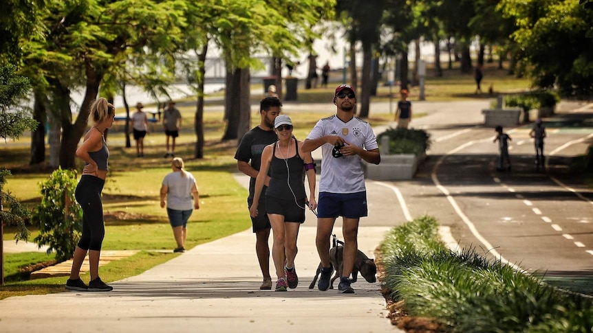 People walking and jogging along a path in a park