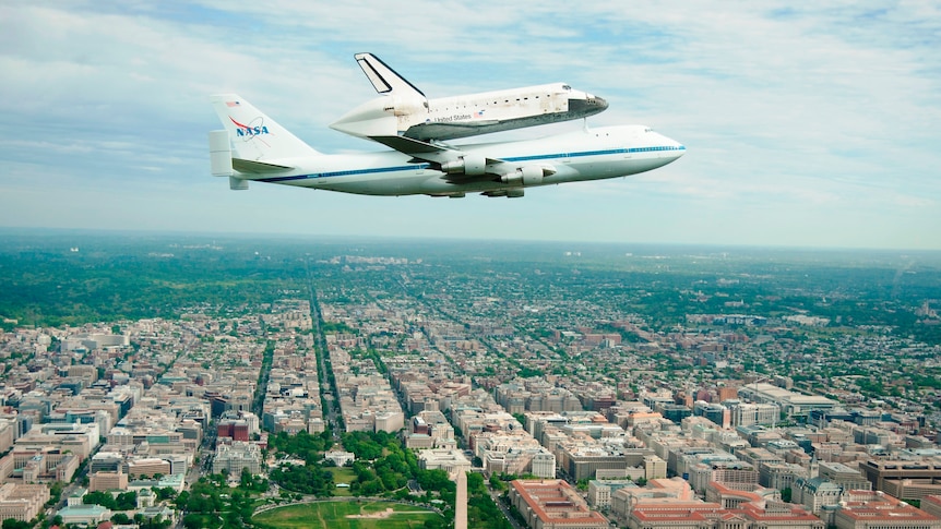 Discovery, mounted atop a Boeing 747, flies over Washington DC