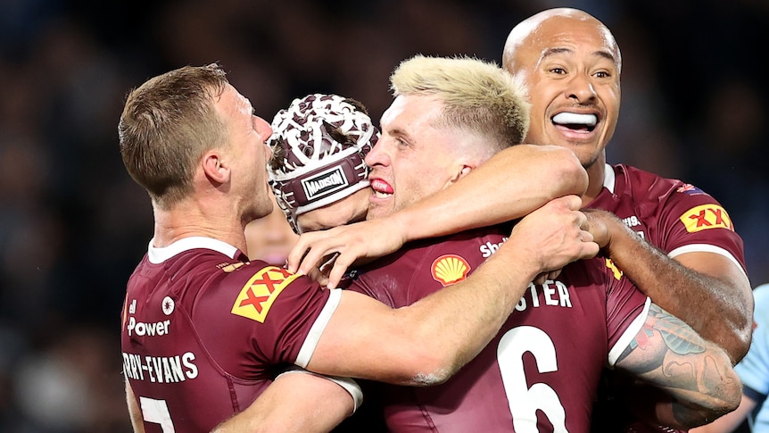 Queensland Maroons teammates Daly Cherry-Evans, Kalyn Ponga, Cameron Munster and Felise Kaufusi hug after winning Origin I.