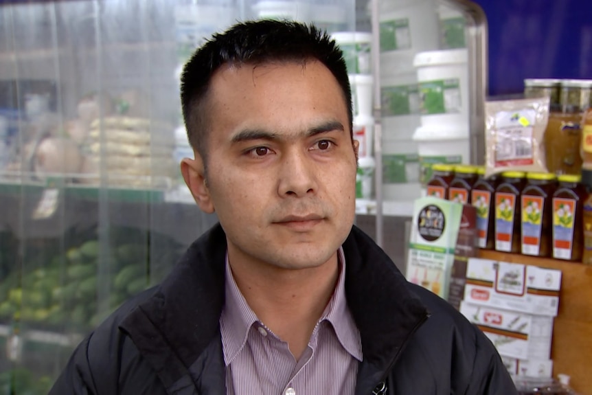 A Hazara man in a shop with goods in the background. 