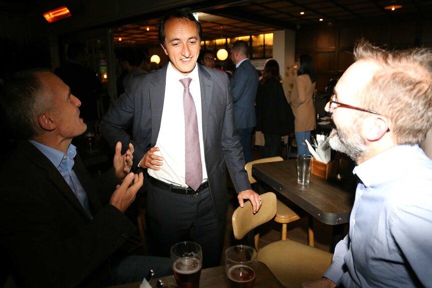 Dave Sharma with two voters at a pub at night