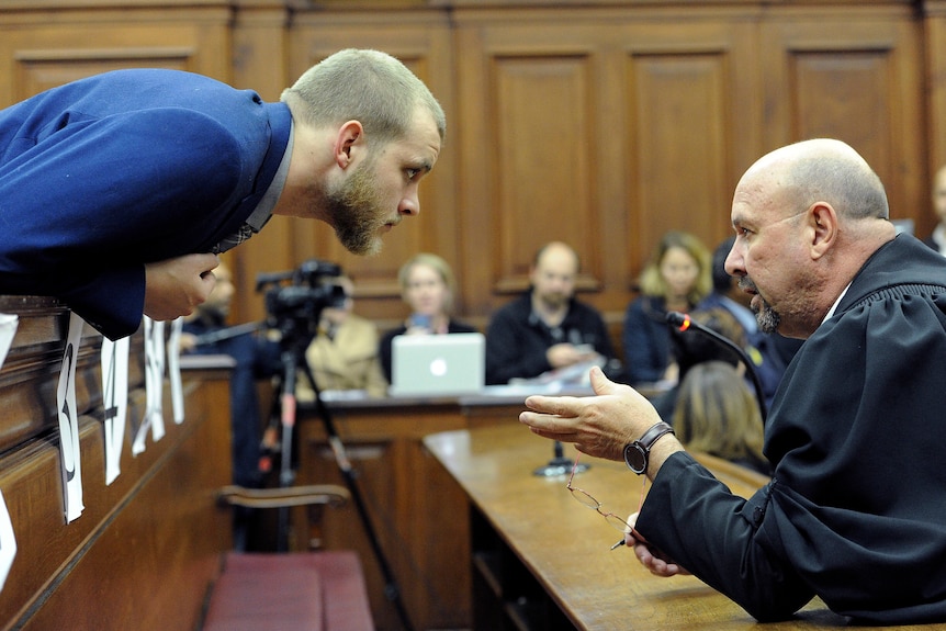 Henri van Breda, left, talks to one of his legal adviser, Piet Botha, right, in the HIgh Court in Cape Town.