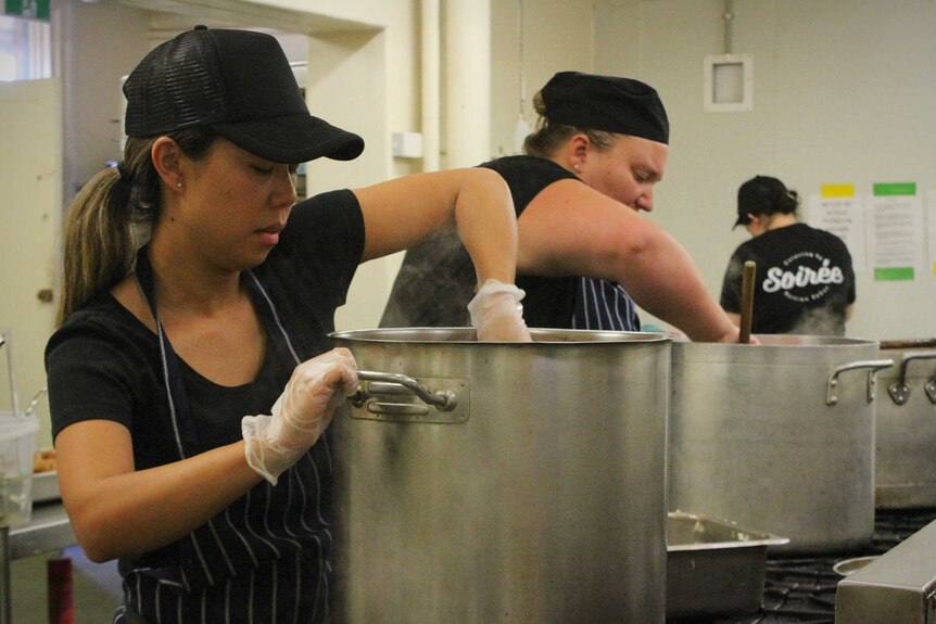 Chefs prepare meals in a commercial kitchen