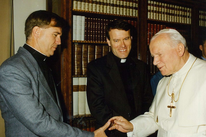 Father Michael Lowcock (left) shakes hands with Pope John Paul II in 1995 at the Vatican.