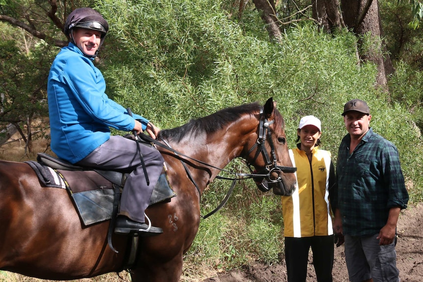 William Pike on a horse with trainers Grant and Alana Williams standing alongside.