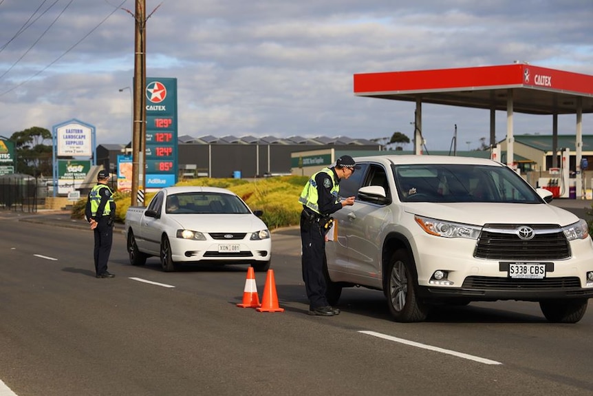 A police officer talks to a driver through the window of a car travelling into Mount Gambier from Victoria.